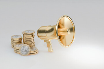 Golden megaphone beside stacks of euro coins, symbolizing financial promotion, marketing success,...