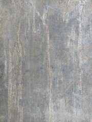 Weathered Concrete Wall Texture. Close-up of weathered concrete wall with natural stains, scratches, and vertical streak patterns, perfect for background or texture use