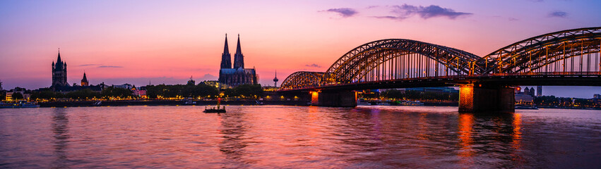 Silhouette skyline landscape of the gothic Cologne Cathedral, Hohenzollern railway and pedestrian bridge, the old town and Great St Martin church in Cologne, Germany after sunset into blue hour © PhotoFires