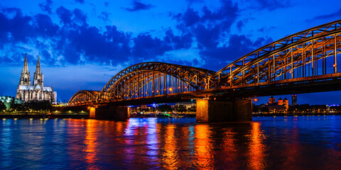 Beautiful night landscape of the Cologne, Germany with gothic cathedral, Hohenzollern Bridge and reflections over the River Rhine