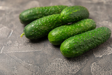 Cucumber on wooden background. Slice of cucumber on background. Fresh organic green cucumbers gherkin. Vegan. Salad ingredient. Farm vegetables. Cut vegetables with knife. Space for text. Copy space