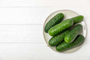 Cucumber on wooden background. Slice of cucumber on background. Fresh organic green cucumbers gherkin. Vegan. Salad ingredient. Farm vegetables. Cut vegetables with knife. Space for text. Copy space