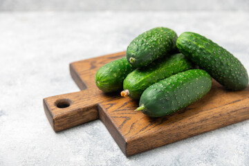 Cucumber on wooden background. Slice of cucumber on background. Fresh organic green cucumbers gherkin. Vegan. Salad ingredient. Farm vegetables. Cut vegetables with knife. Space for text. Copy space