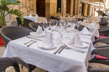Typical European sidewalk restaurant scene with elegant table setting