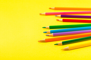Colored pencils on a bright colored background. Equipment for coloring. Stationery for...