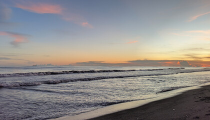 Beautiful tropical beach sunset with gentle ocean waves and colorful sky view