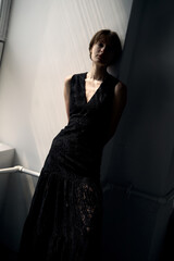 Artistic silhouette of woman in black dress against minimalist white background