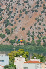 Blue and yellow firefighting helicopter flying over lake to collect water for extinguishing fire