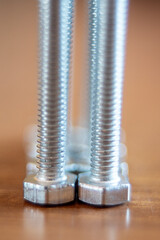 Verticale di macro di filettatura di bulloni in piedi sul tavolo di legno