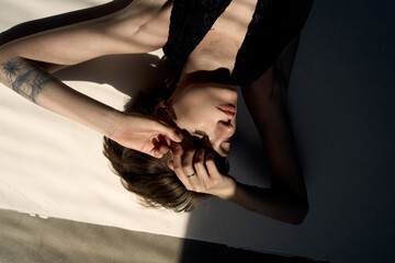 Contemplative portrait with natural window lighting creating soft shadows and peaceful atmospheric mood in warm tones