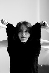 Monochrome artistic portrait featuring woman with arms raised in celebratory gesture showing...