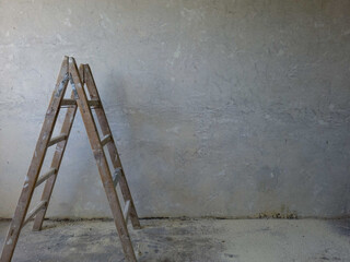 Painters wooden ladder against a bare wall