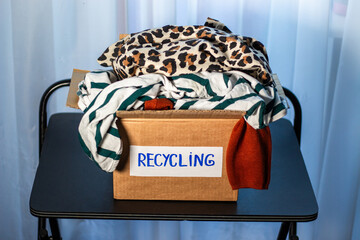 Large box packed with old clothes that are prepared for recycling. Image for Upcycling services....