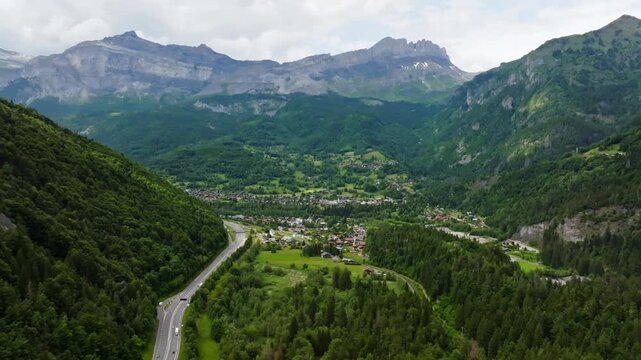 Aerial view approaching the Servoz town, cloudy, summer day in Alps, France