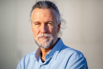 Elderly man looking confidently into camera with soft light
