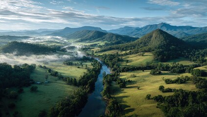 Misty valley river winds through rolling hills