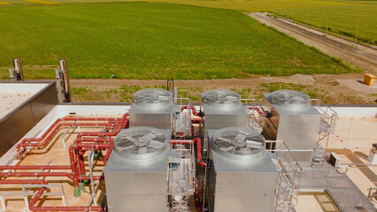 Industrial hvac system cooling a building with green field in background