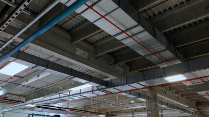 Ventilation system and fire sprinkler pipes crossing concrete ceiling