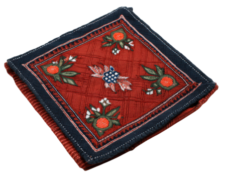 Red batik cloth square with ethnic floral pattern traditional textile folded neatly vibrant colors decorative handmade cultural artistic and elegant design