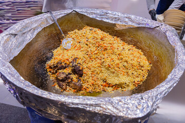 Large serving dish filled with colorful rice and meat dish, showcasing vibrant culinary presentation