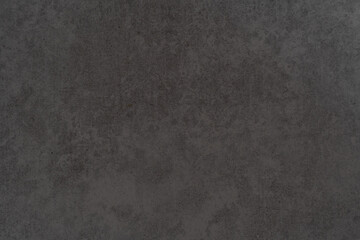 Textured dark surface with subtle variations in tone and pattern under soft lighting