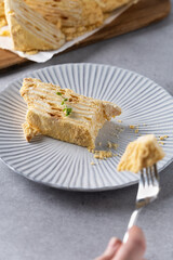 Delicious layered dessert served on a textured plate with a fork beside it