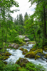 Fototapeta premium Gollinger Wassermühle von oben beim Wasserfall mit der Wasserleitung. Traditionelle Mühle in alpiner Landschaft.