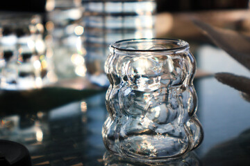 Glass of water on a wooden table in a cafe. Minimal lifestyle, beverage, and freshness concept.
