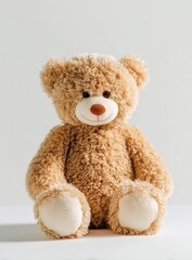 Obraz premium A cuddly and soft plush toy teddy bear sits on a white , offering comfort and companionship with its friendly expression.
