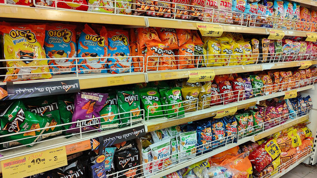 Rishon Lezion, Israel - 5 Aug 2025. Shelves stocked with Osem Bamba, Bissli, and chips, with price tags. Rising prices, inflation, economic crisis, taxes and price increase in Israel in shekels.