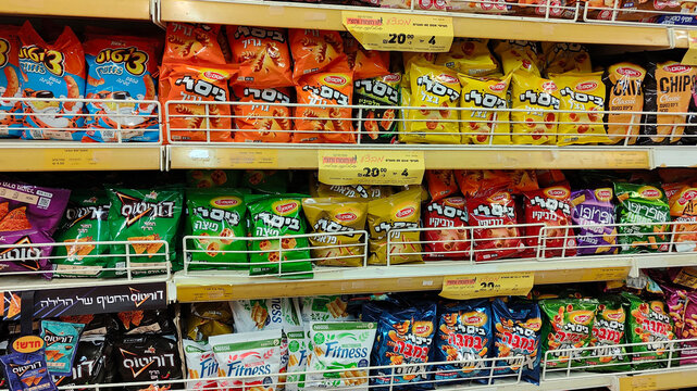 Rishon Lezion, Israel - 5 Aug 2025. Shelves stocked with Osem Bamba, Bissli, and chips, with price tags. Rising prices, inflation, economic crisis, taxes and price increase in Israel in shekels.