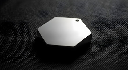 Hexagonal Metallic Object on Dark Fabric A Minimalist Aesthetic