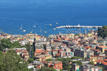 Naklejka premium Camogli, Italy - 11 July 2025. Yachts, boats in bay of Liguria. Sea and tourism in Italy. Traditional buildings. Background for design.
