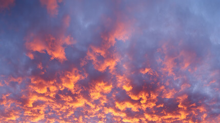 Dramatic sunrise with gradient orange and purple clouds, creating a panoramic abstract sky view.