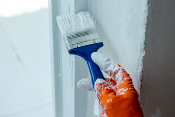 Photo of painting with white paint on wood. Interior painting. Making repairs, painting. White paint