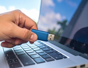 Hand Inserting Blue Flash Drive Into Laptop