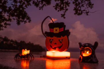 Concept: Halloween beach and ocean background with spider, witch and ghost pumpkin. Dark, scary tone.