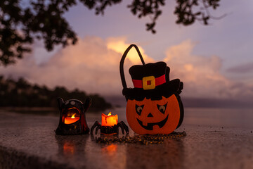 Concept: Halloween beach and ocean background with spider, witch and ghost pumpkin. Dark, scary tone.