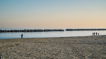 The beach of Marina di Ravenna in a late afternoon of winter with the horizontal heavy blocks...