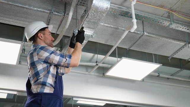 Hvac technician installing air duct system in building