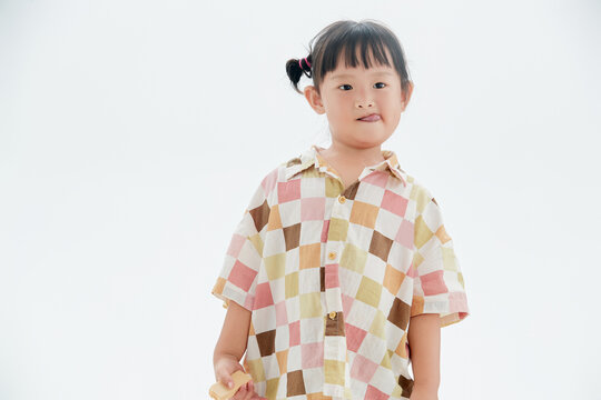 Playful and adorable Chinese little girl on a white background