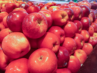 Fresh Red Apples in Pile. 
A vibrant display of fresh red apples stacked together in a market.
