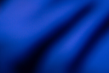 This image features an abstract blue background with smooth gradients and dark shadows creating a sense of depth and movement.