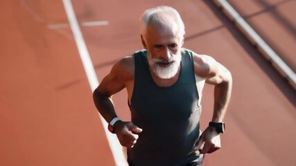 Athlete racing in competition, middle aged man with beard wearing sportswear, outdoor track event