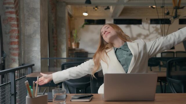 Smiling happy relaxed Caucasian businesswoman girl female business woman finished laptop typing complete computer work online job done stretching hands sitting at table resting pause break in office