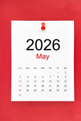 May 2026 calendar page with push pin on red color background.