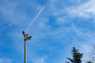 Security camera on a light pole on the street.Security camera and urban video in front of blue sky. Outdoor cctv video surveillance cameras. Safety system area control outdoor with copy space.