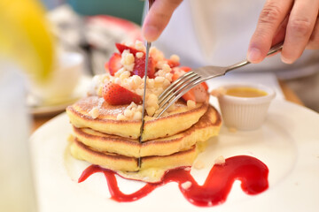 いちごのパンケーキをカットする