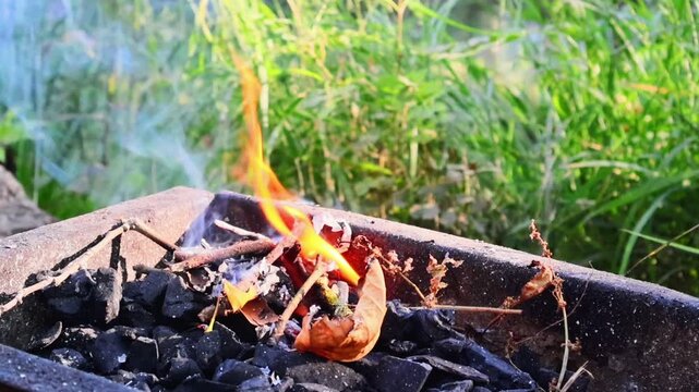 Close-up video of burning wood logs on a barbecue grill, showing vivid flames and glowing embers. Perfect for outdoor cooking, camping, and cozy fire scenes. This footage captures the warmth and rusti
