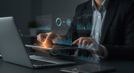 Business professional analyzing financial data on a digital tablet with holographic charts